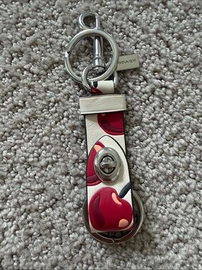 New Coach Trigger Snap Bag Charm with a Cherry Print in Chalk White.